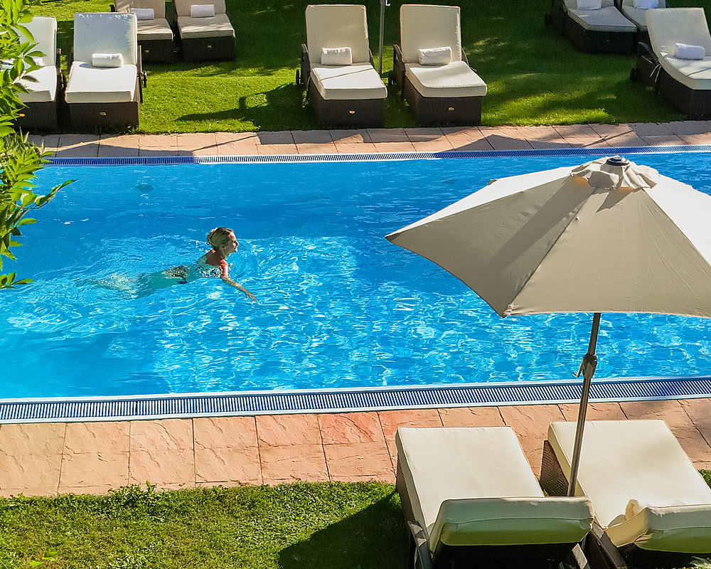 Foto: Beheitztes Freischwimmbad und Garten mit Liegen des Alpenhotel Tirolerhofs in Neustift Tirol